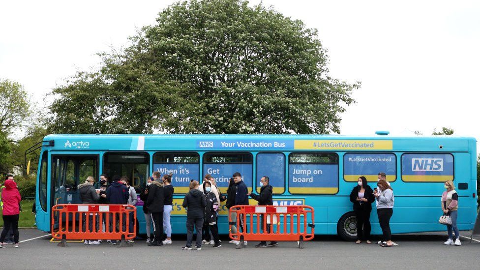 People queuing at a Covid-19 vaccination bus outside Anfield stadium prior to a Premier League match between Liverpool and Crystal Palace