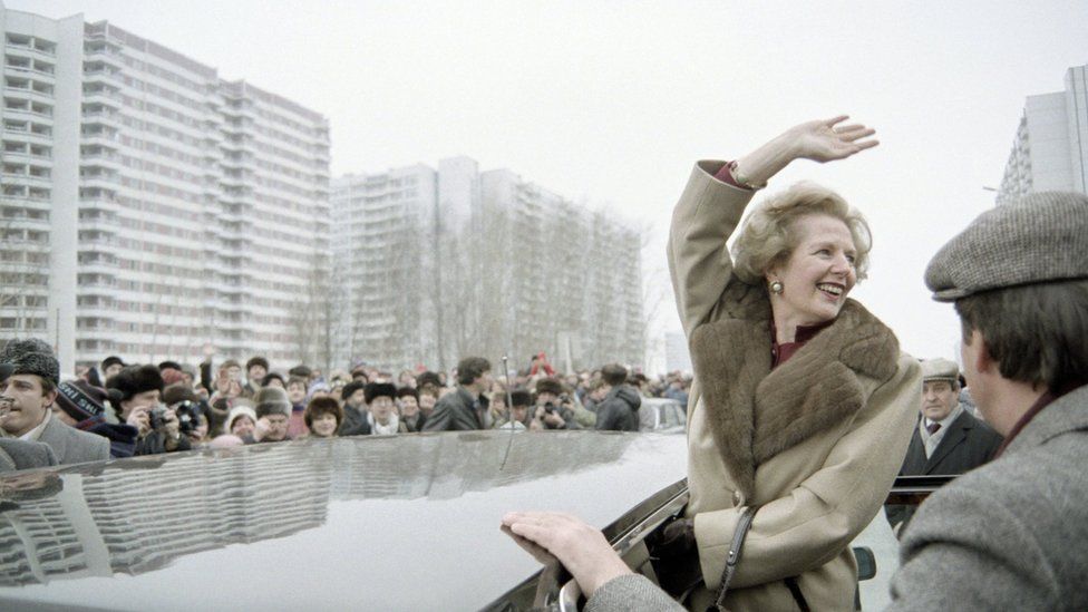 Margaret Thatcher leans out of a black car to greet a Moscow crowd in 1987