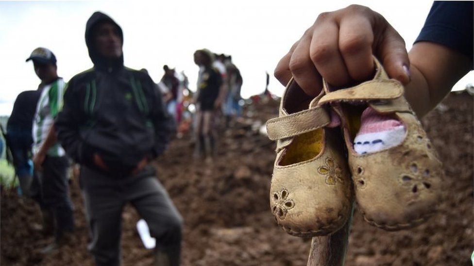 A person shows some children's shoes after a landslide, in the village Portachuelo, in the municipality of Rosas, Cauca, Colombia, 22 April 2019.