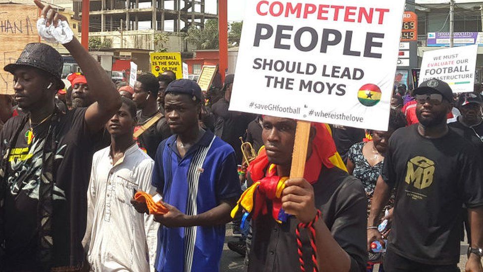 Thousands of fans holding banners gather in Accra. One banner reads: "Competent people should leader the Moys".