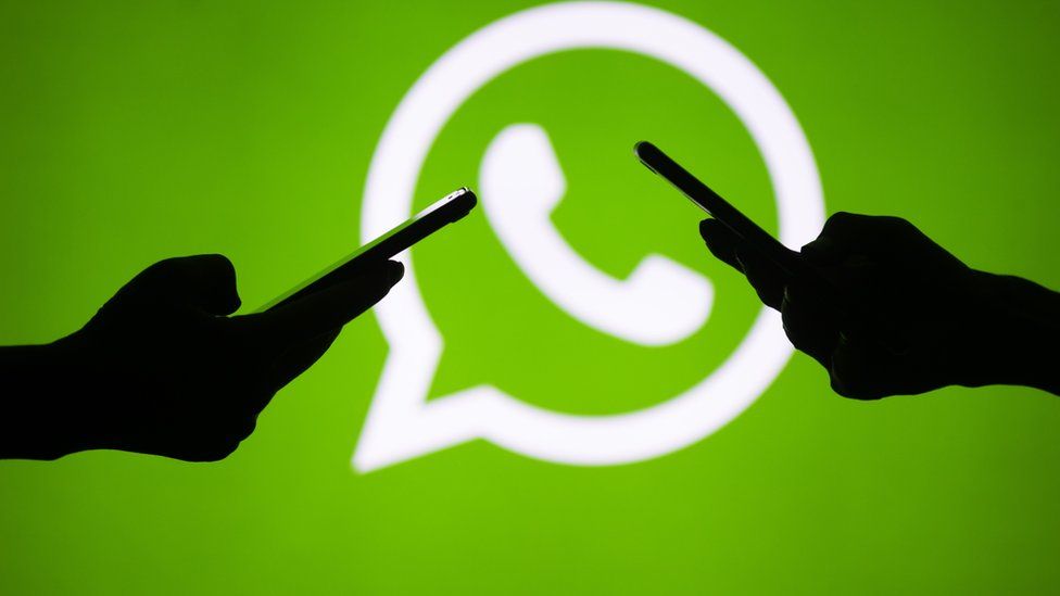 Two mobile phones and the WhatsApp logo