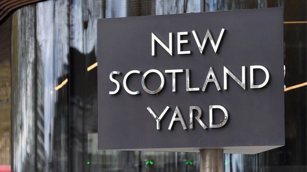 Police officers stand outside New Scotland Yard in London,