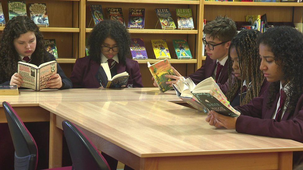 School pupils reading in library