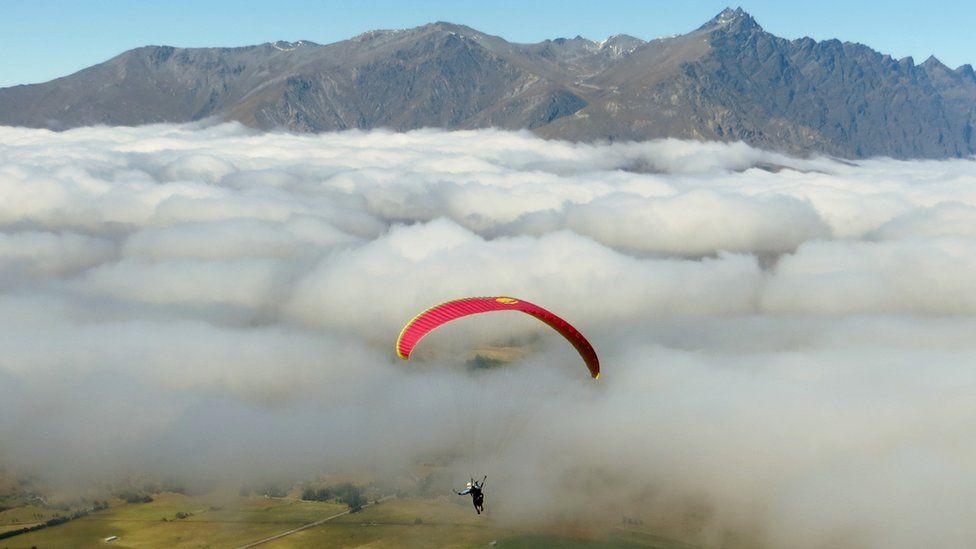Paraglider above the clouds