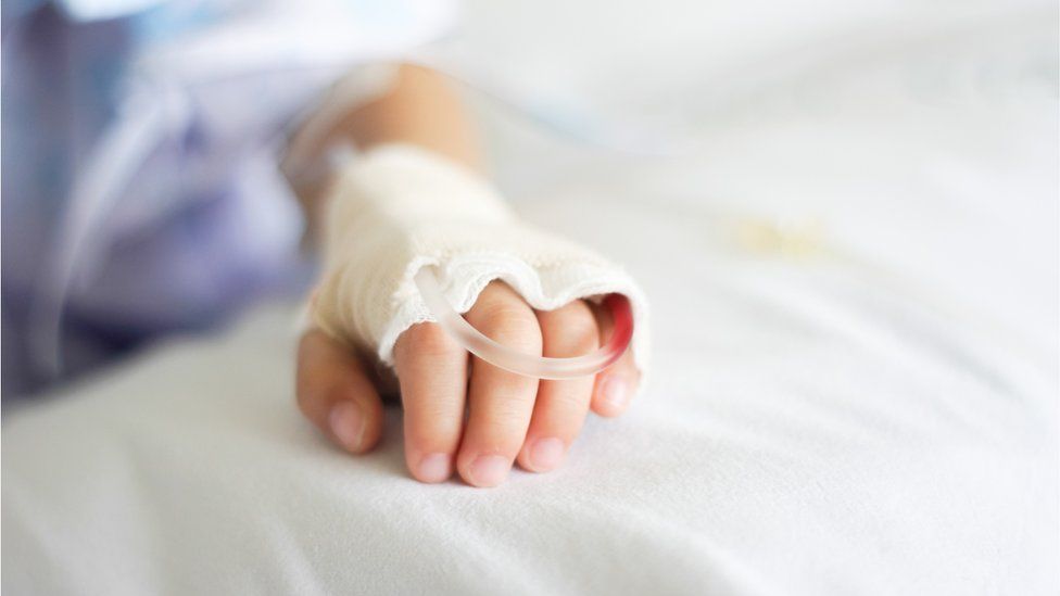 An intravenous drip in a child patient's hand