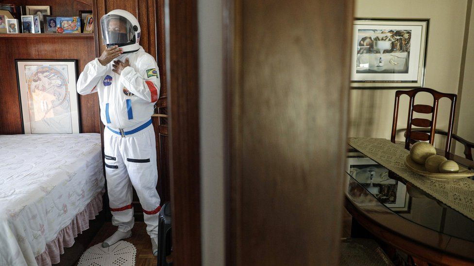 Tercio Galdino, 66, wears his protective "space suit" inside his house