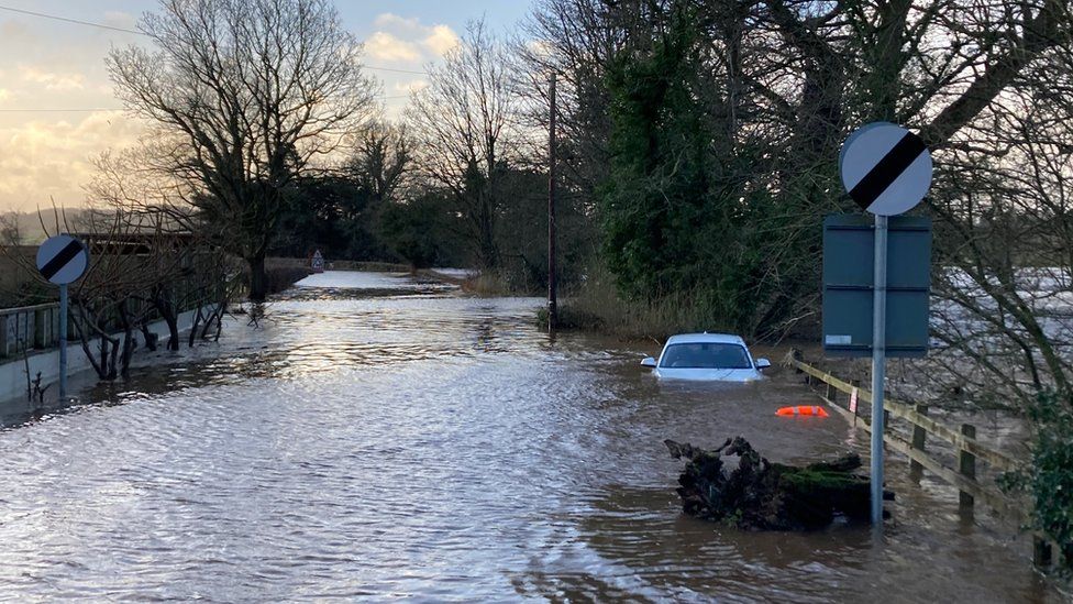 Road and car flooded beside the River Eden