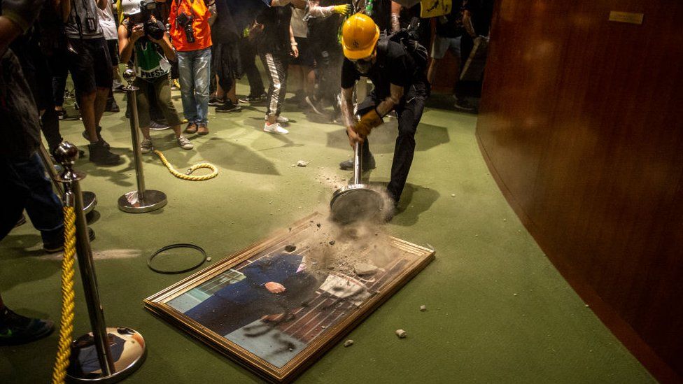 Protesters are seen smashing a portrait of Legislative Council Andrew Leung in Hong Kong