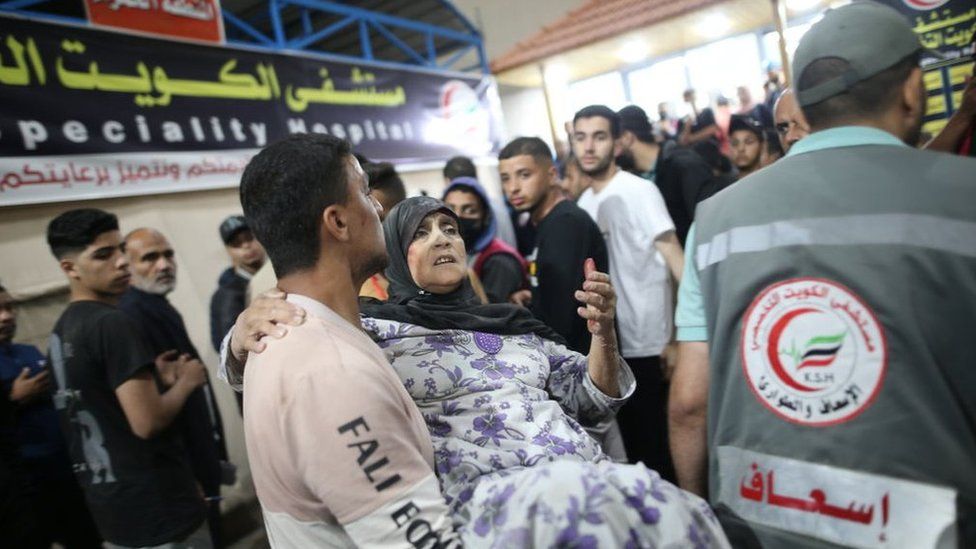 An injured woman is carried into the Kuwaiti Specialist Hospital in Rafah, in the southern Gaza Strip (8 May 2024)