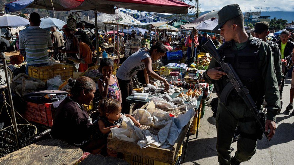 A member of the National Guard walks around the municipal market of Coche, a neighbourhood of Caracas, during an inspection to control prices, on June 20, 2018