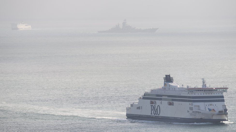 A passenger ferry passes the Russian aircraft carrier