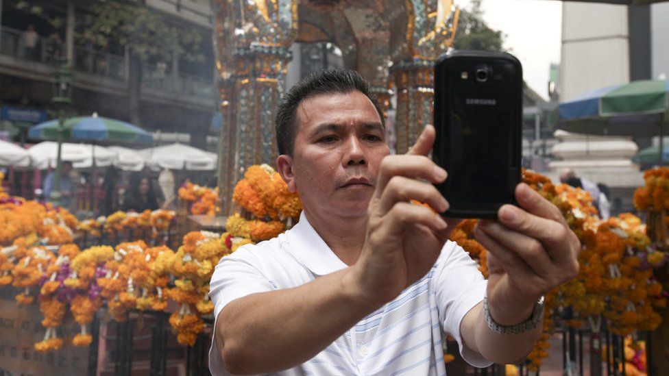 Man takes a selfie at Erawan shrine