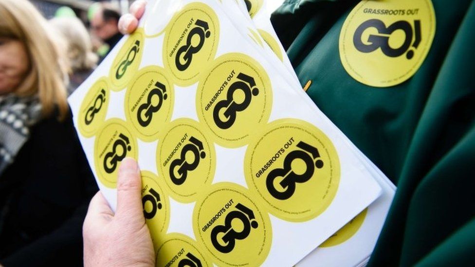 An activist holds "Grassroots Out" stickers in Wellingborough