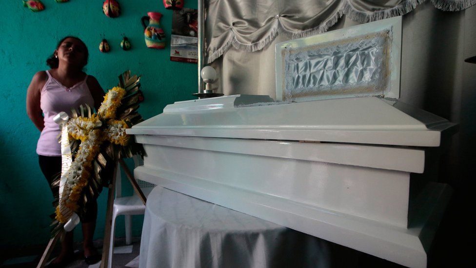 Karina Navarrete stands next to the coffin of her fifteen-month-old son Teiler Lorio Navarrete