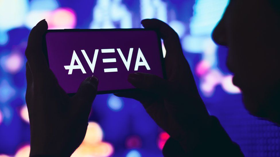 Woman hols phone with Aveva logo