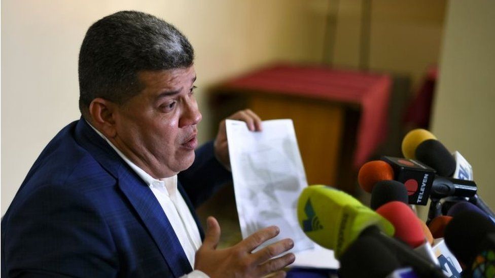 Luis Parra holds up a paper during a news conference