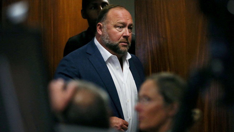 Alex Jones walks into the courtroom in front of Scarlett Lewis and Neil Heslin, the parents of 6-year-old Sand Hook shooting victim Jesse Lewis, at the Travis County Courthouse in Austin, Texas, U.S. July 28, 2022