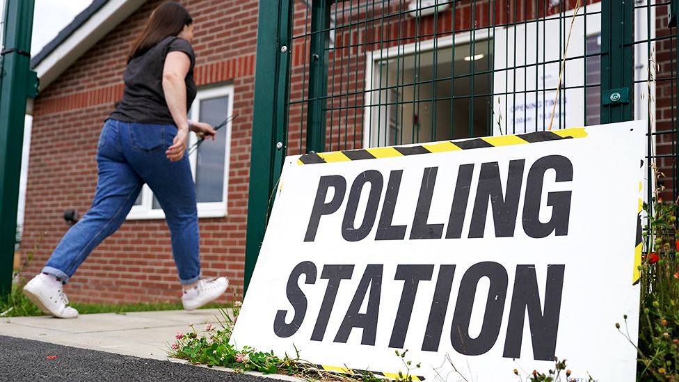 A member of polling station staff returns after putting up signs as polls open in the Selby and Ainsty by-election on July 20, 2023 in Selby, England