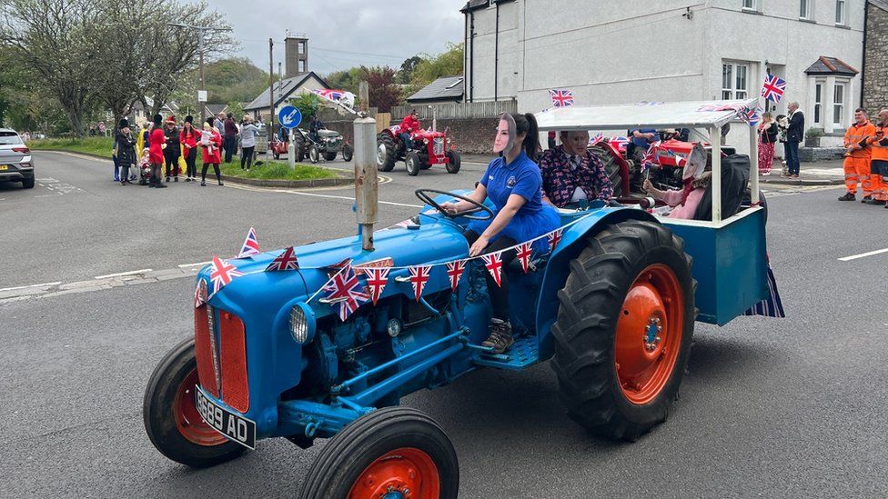 tractor with the driver wearing a Kate mask and Charles and Camilla masked actors in the back carriage