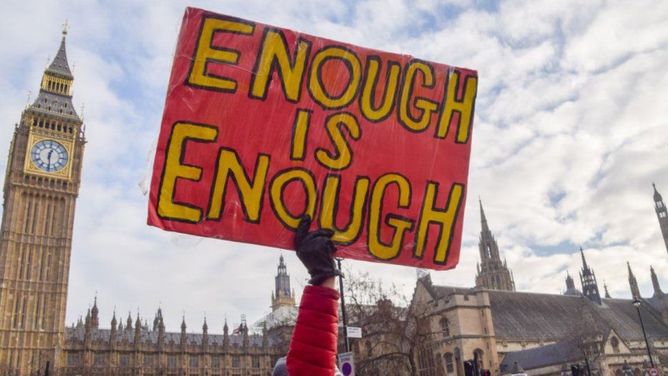 A sign saying 'Enough is enough' outside the House of Parliament, London