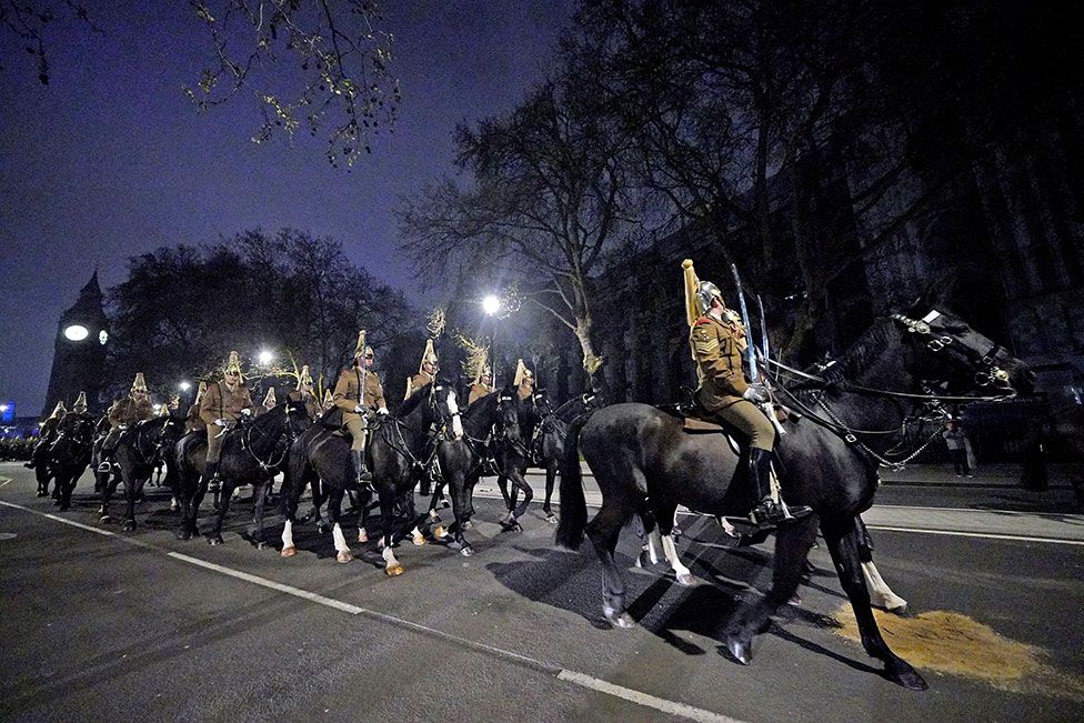 Members of the military outside Westminster Abbey, central London, during a night time rehearsal for the coronation of King Charles III on 18 April 2023