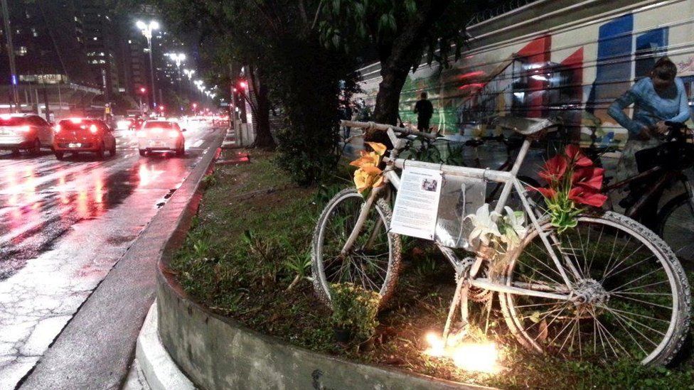 A bike with flowers is left as a memorial to a cyclist who died