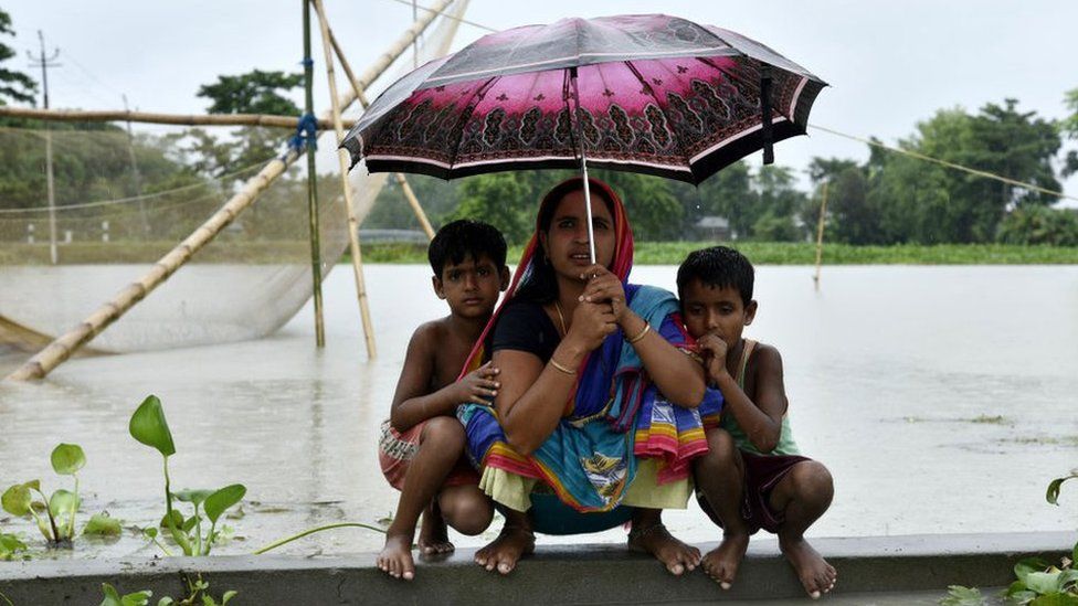 Woman and children take shelter on a height in the flood effected Kalgachia of Barpeta district of Assam, India on July 12, 2019.