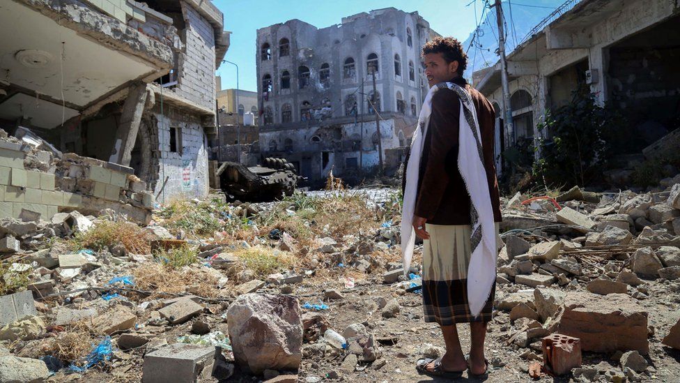 A Yemeni man inspects the damage on a street in Taiz, following clashes between pro-government militants and Huthi rebels