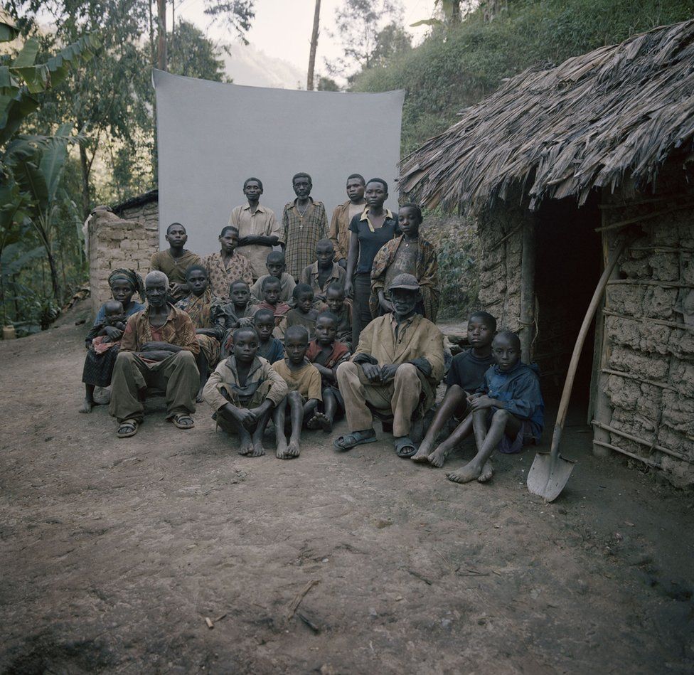 A group sit in front of a backdrop.