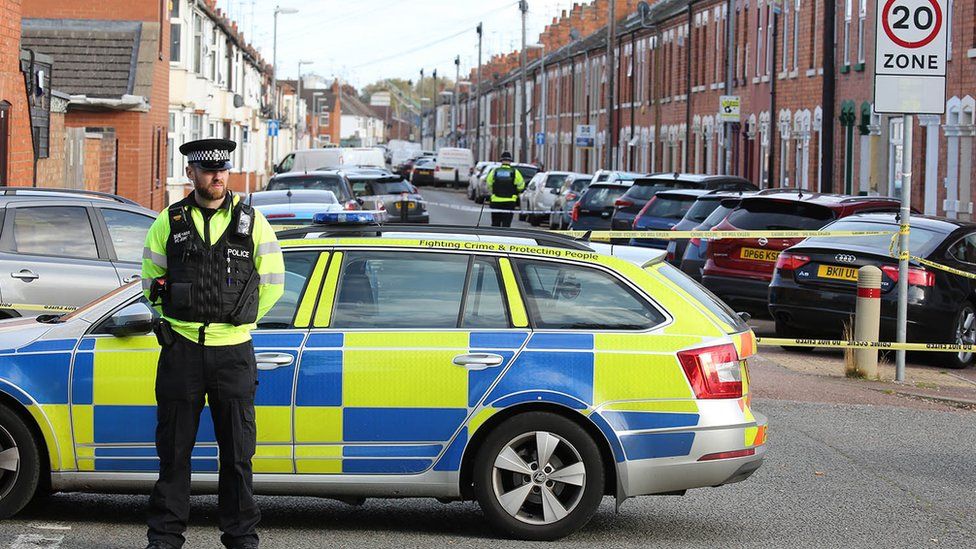 Policeman standing next to a police car