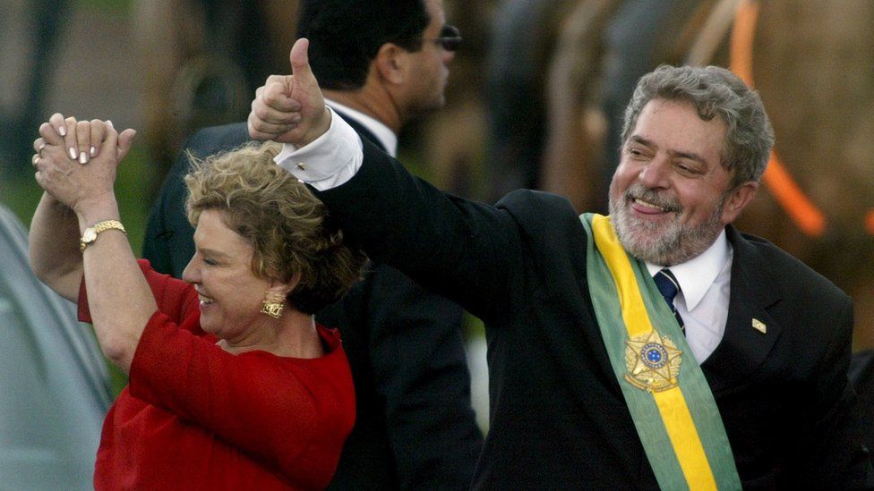 1 Jan 2003: Luiz Inacio Lula da Silva gestures to supporters as he rides past them with his wife, Marisa, after he received the presidential sash