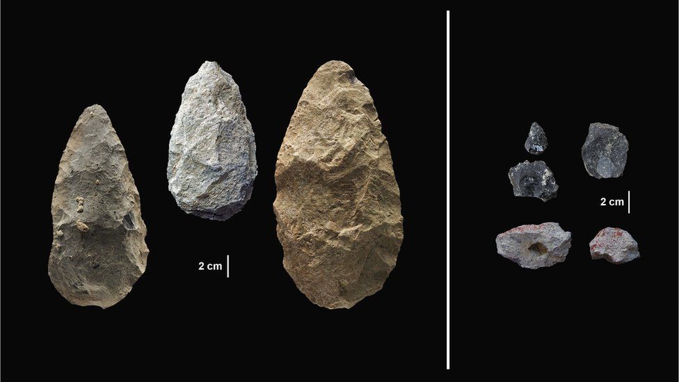 Three pear shaped hand axes. Three small obsidian points, black in colour. Two small, irregular blocks of pigment.