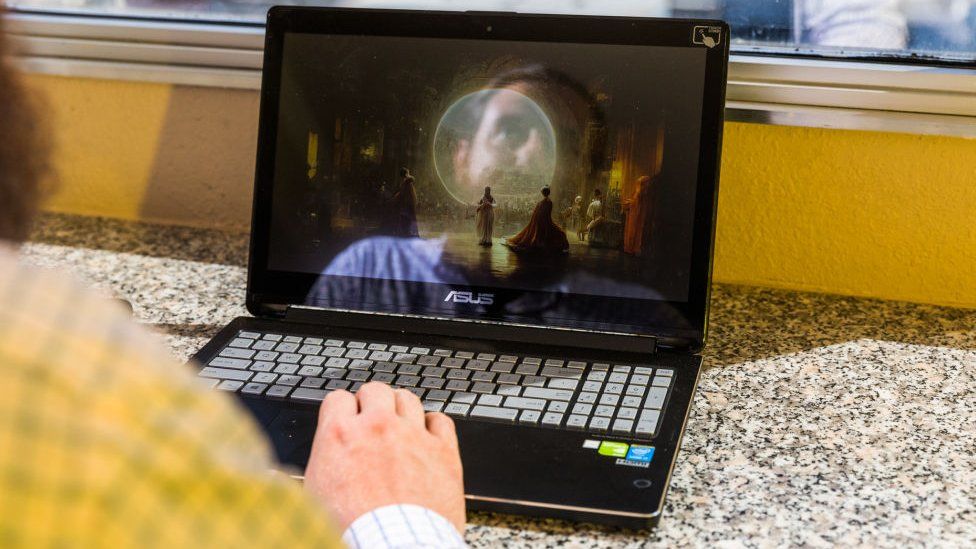 Jason Allen avec une photo de son œuvre sur un ordinateur portable