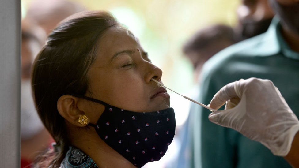 Медицинский работник берет образец мазка для теста на Covid-19 в районной больнице в секторе 30, 28 июня 2022 года в Нойде, Индия. || |