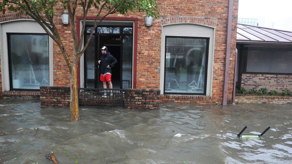 Херст Баттс смотрит на затопленную улицу перед своим офисом, когда ураган Салли проходит 16 сентября 2020 года в Пенсаколе, Флорида