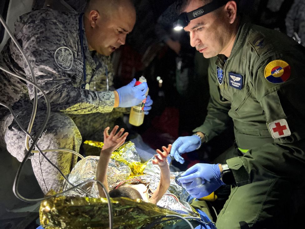 Anëtarët e Forcave Ajrore Kolumbiane u japin kujdes mjekësor brenda një avioni fëmijëve të mbijetuar të një aksidenti avioni Cessna 206 në xhunglën e trashë, ndërsa ata transferohen në Bogota me ajër në San Jose del Guaviare, Kolumbi, 9 qershor 2023.