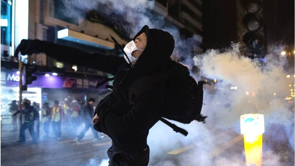 A protester reacts after police fire tear gas to disperse bystanders in a protest in Jordan district in Hong Kong, on early December 25, 2019