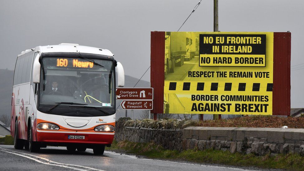 A coach passes a campaign sign rejecting a hard border in Ireland