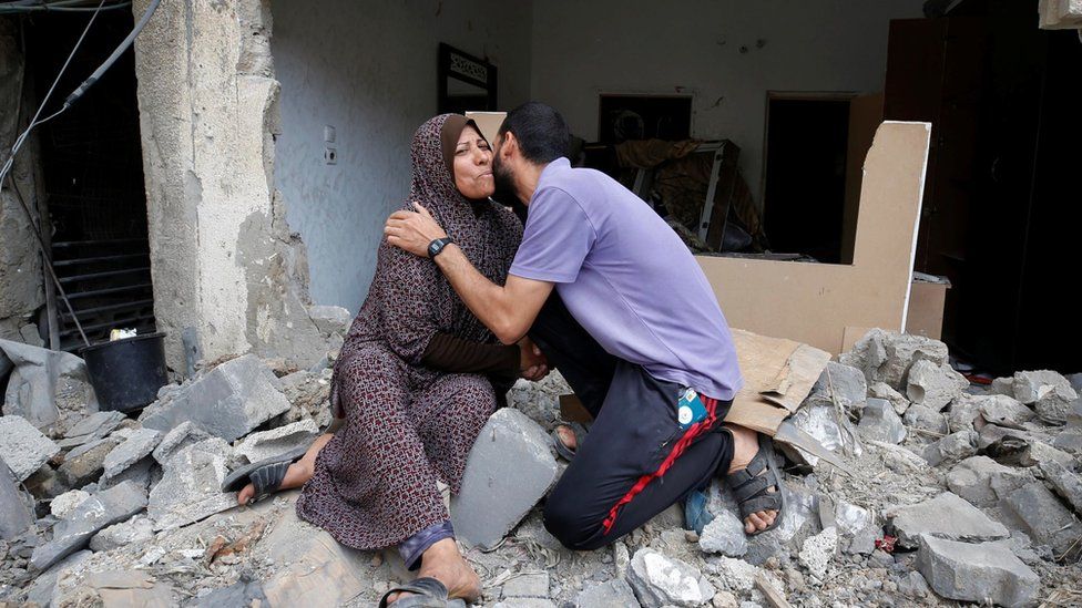 A Palestinian woman is kissed by her son after returning to their destroyed house following Israel- Hamas truce, in Beit Hanoun in the northern Gaza Strip, May 21, 2021.
