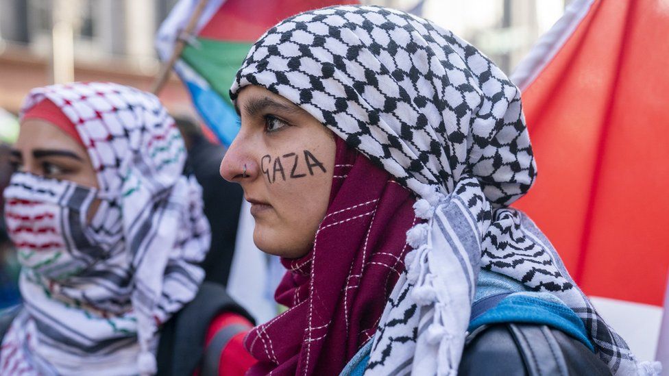 A pro-Palestinian protester with Gaza written on her cheek