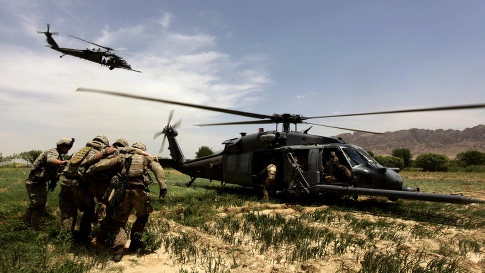 US troops leading a wounded soldier to a helicopter in Afghanistan, May 2010