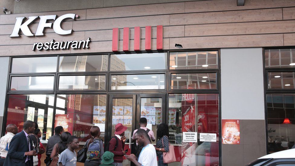 Members of the public walk past one of the three Kentucky Fried Chicken (KFC) branches which have closed down in Harare, Zimbabwe, 09 October 2018
