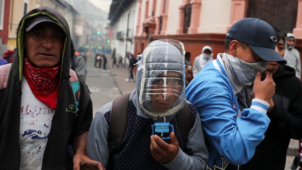 A protester uses a plastic bottle as a gas mask