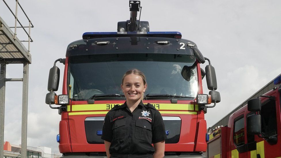 Macy Barker stands in front of a fire truck