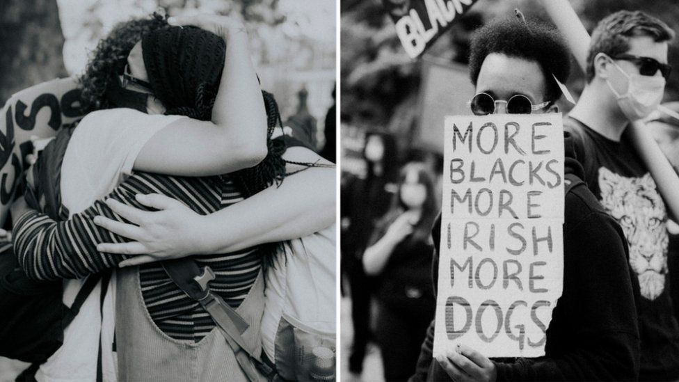 Woman hugging someone and man holding placard