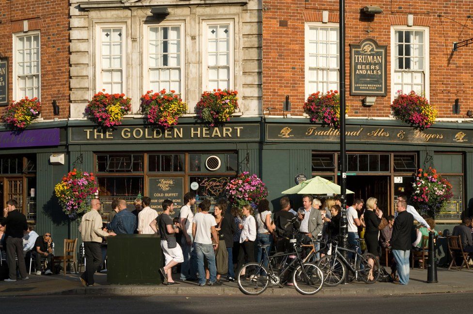 People drink outside the Golden Heart pub in Spitalfields