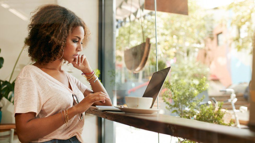 Young woman working in a cafe on a laptop.