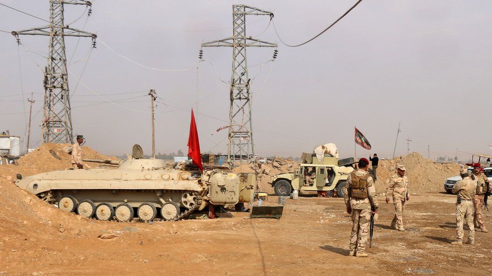 Iraqi forces stand guard near the al-Qaim border crossing between Syria and Iraq on 8 November 2017