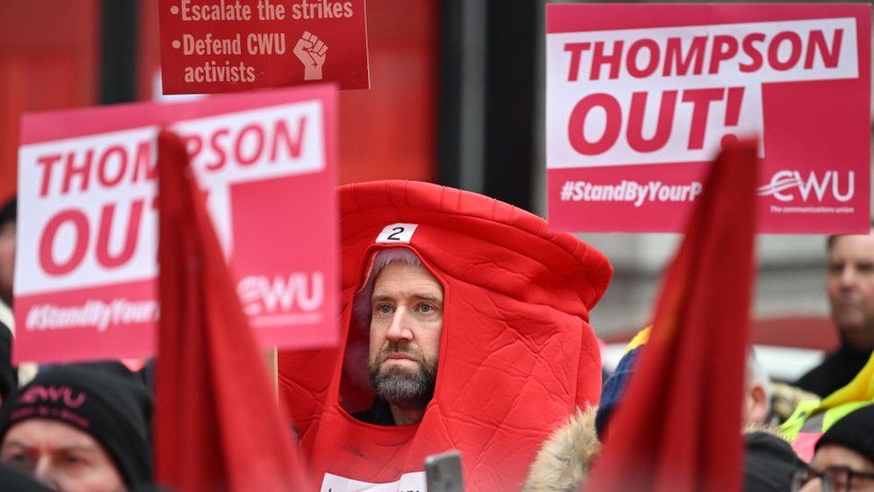 Striking Royal Mail staff with one dressed as a postbox