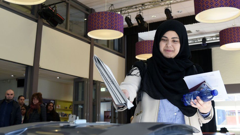 A Dutch woman wearing a headscarf casts her ballot at a polling station in The Hague, 15 March 2017